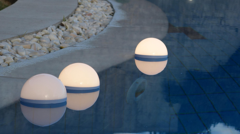 White floating lights along the edge of a pool