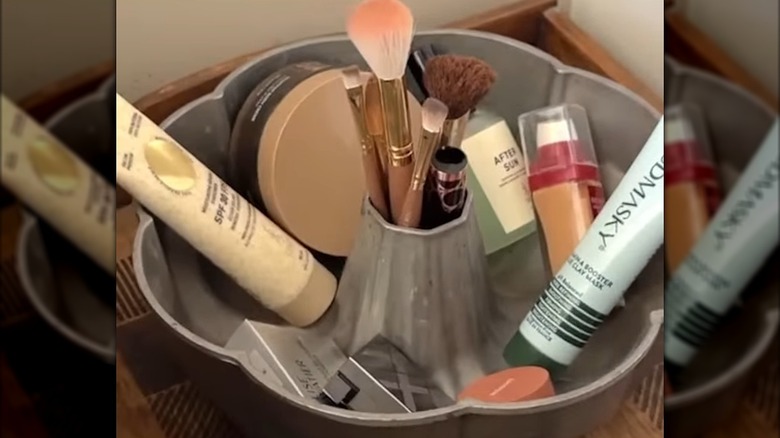 makeup brushes and products stored in bundt pan