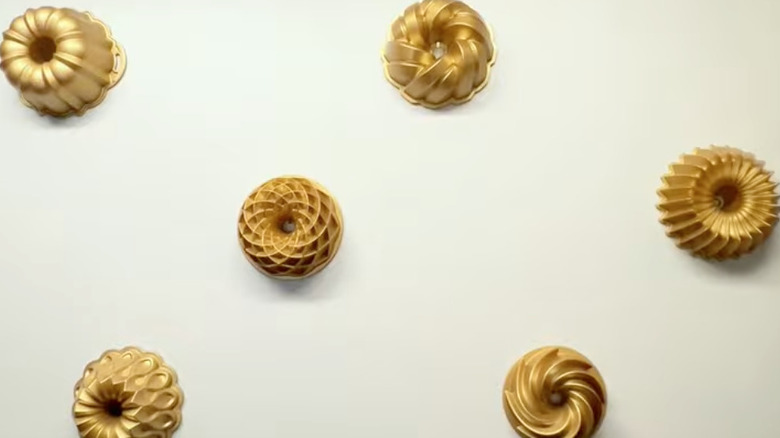 bronze bundt pans hanging up on wall