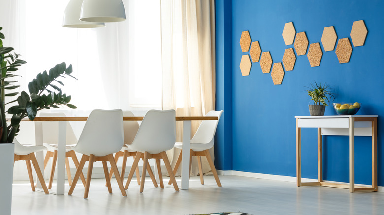 A dining room with a bright blue wall