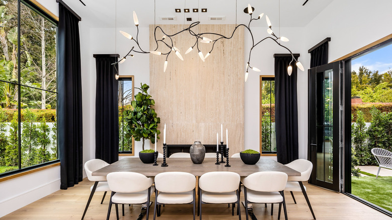 A dining room with a very large modern ceiling fixture