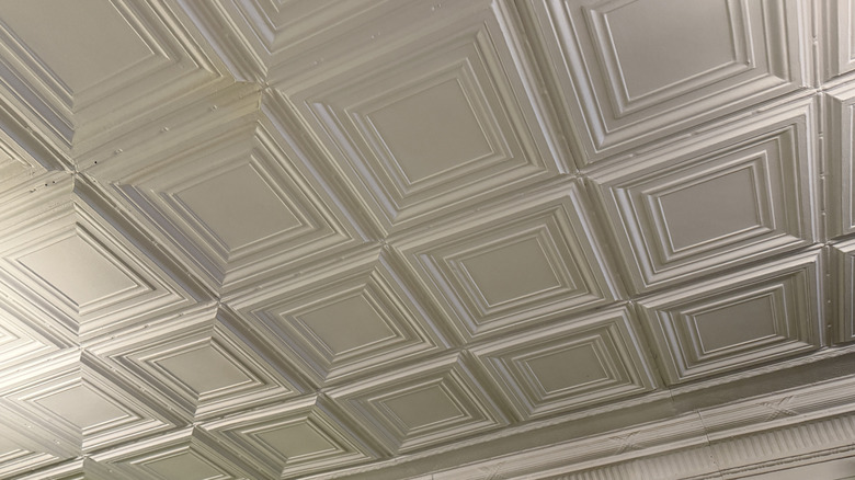 A ceiling with white tin tiles