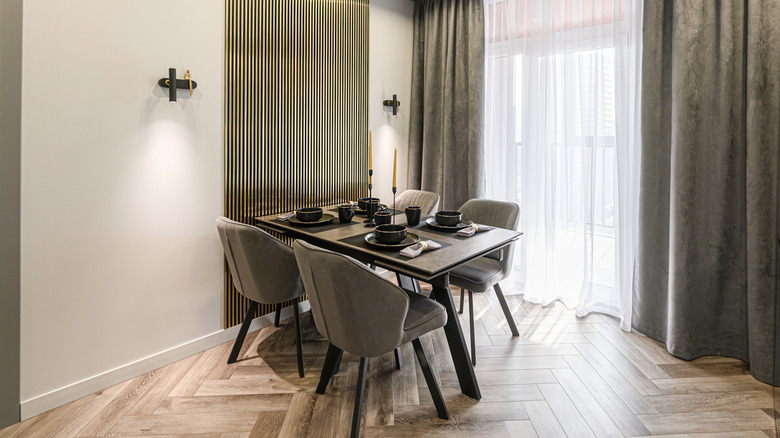A modern dining area with wall sconces