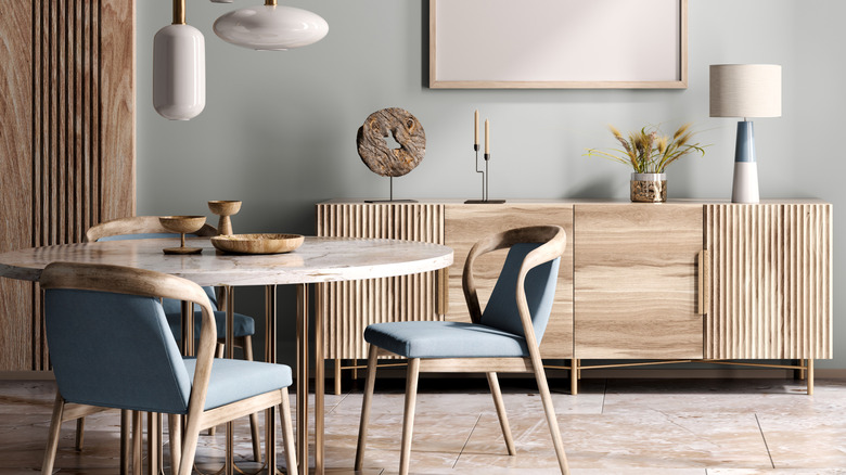 A dining room with decor in different finishes and textures sitting on the buffet