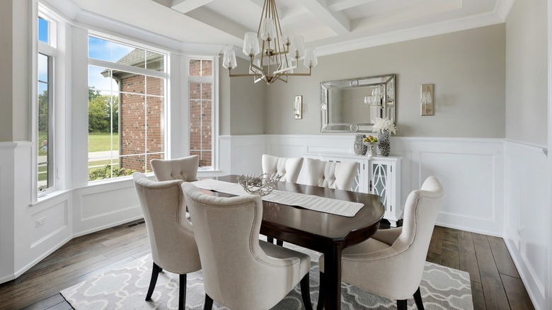 A dining room with wooden floors and an area rug