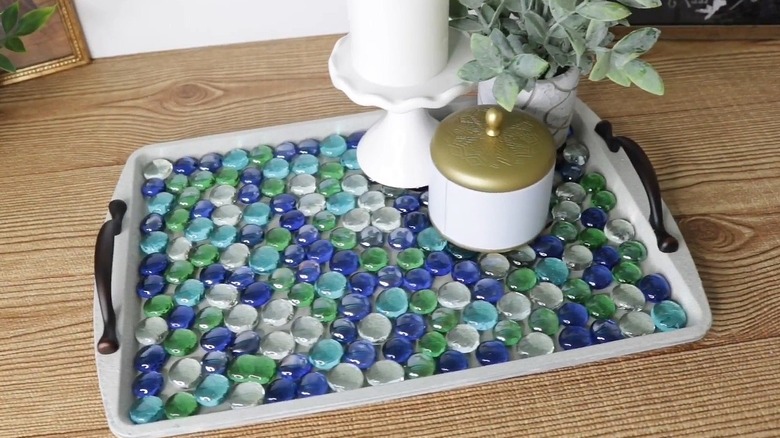 Serving tray covered in Dollar Tree gems with a candle, jar, and plant on top