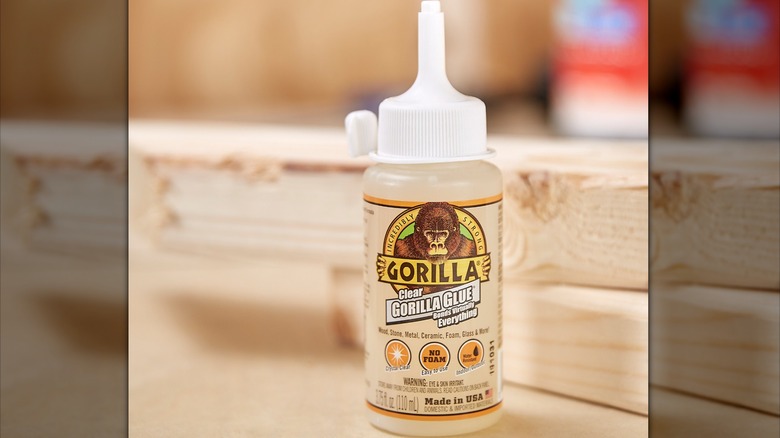 person applying Gorilla Clear Glue to wood trim