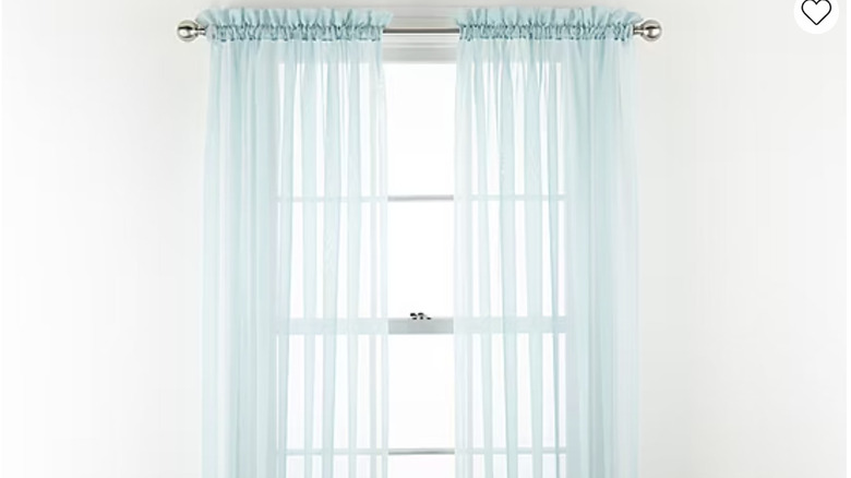 Sheer blue curtain panels hang from a silver rod.