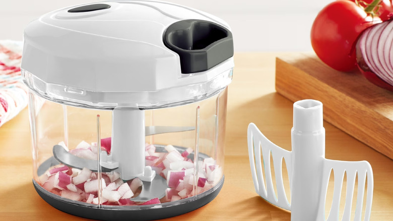 A small food chopper with onions inside