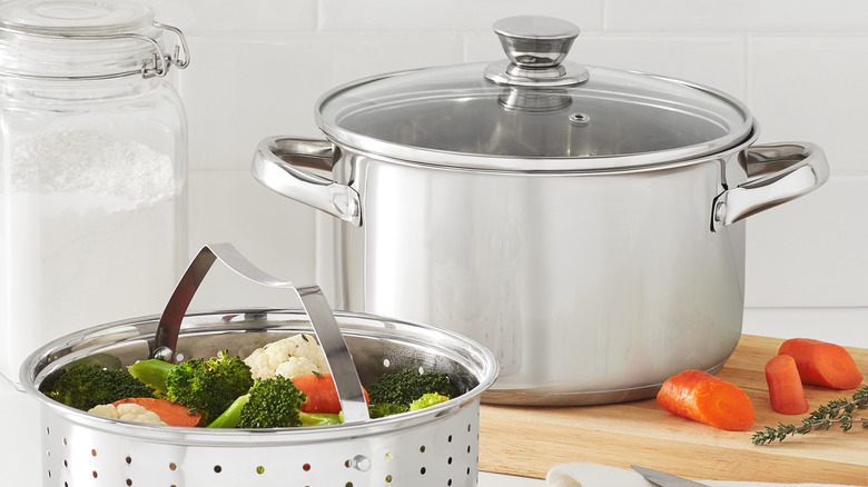 Stainless steel steamer pot with colander full of vegetables
