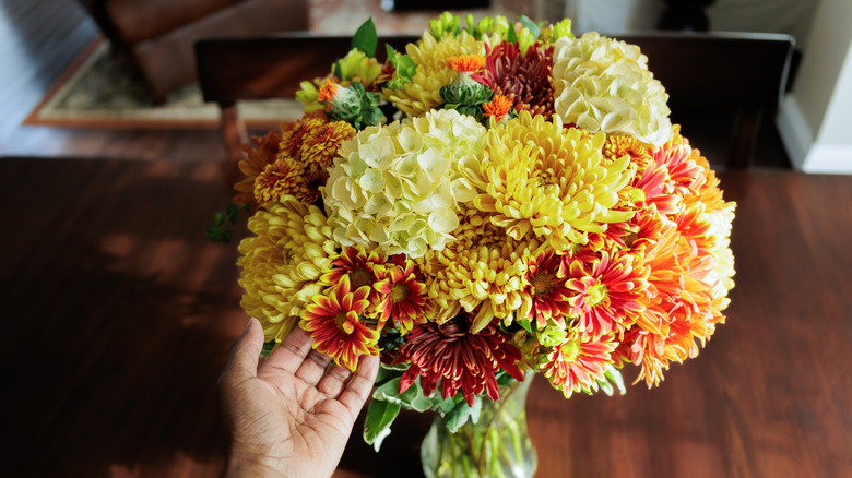 A flower arrangement made out of fall flowers and leaves