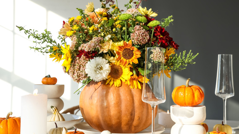 Carved pumpkin holding a fall floral arrangement