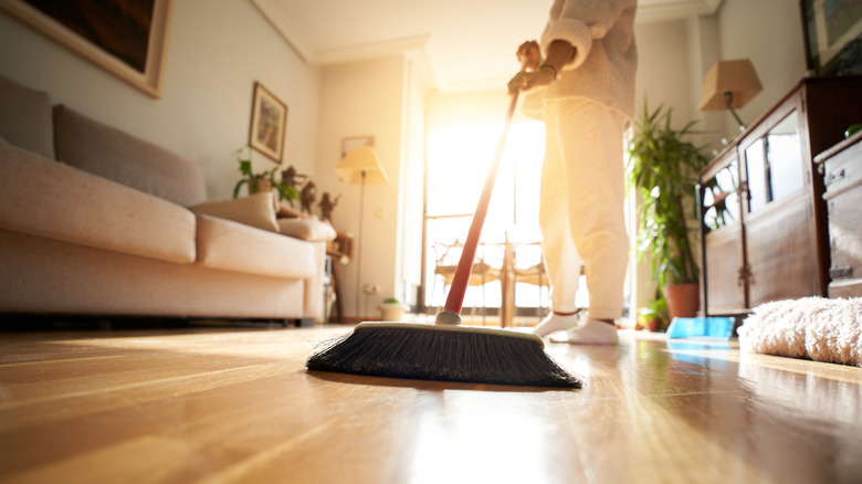 person sweeping wood floor