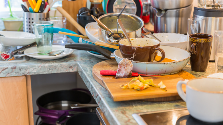 Messy kitchen with pile of dirty dishes