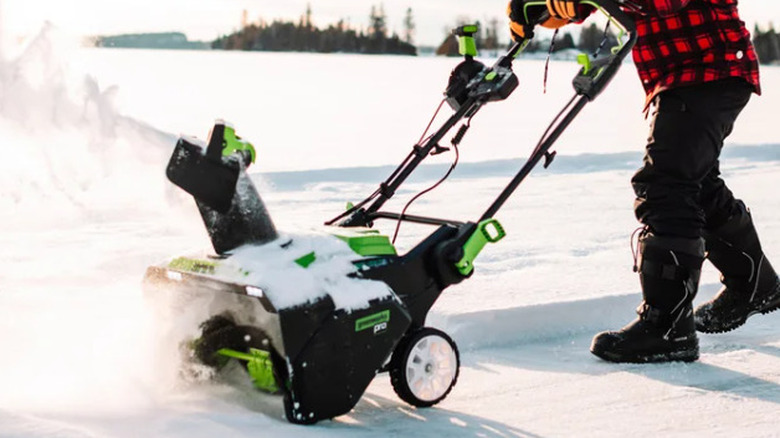 Man using Greenworks 80V 22" Snow Thrower in winter time