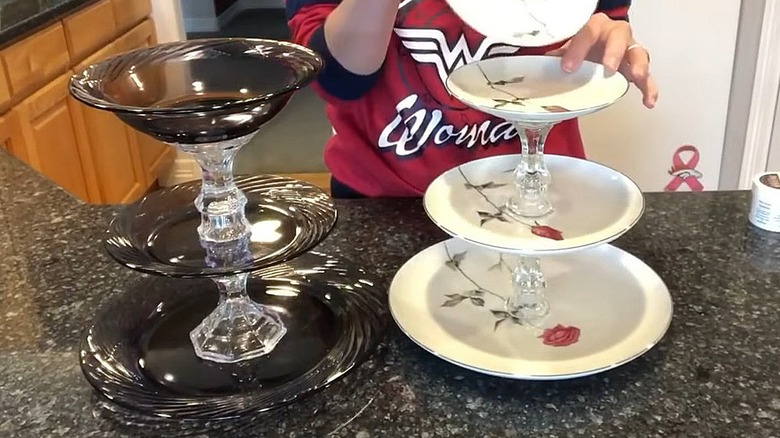Three-tier stand made with chargers, plates, bowls, and candle holders