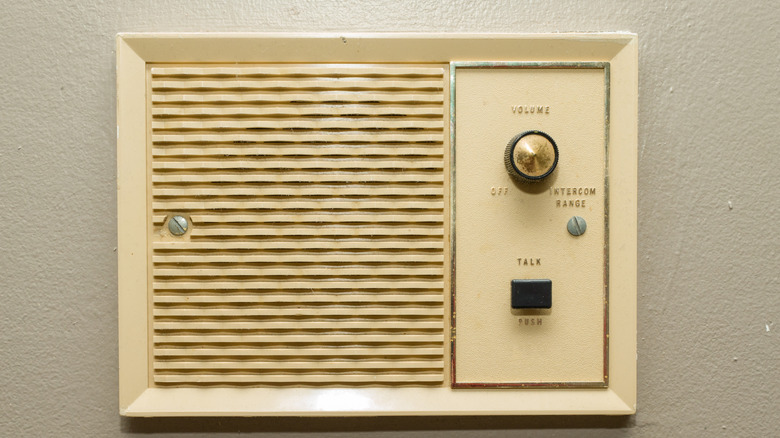 An old home intercom panel mounted on a wall