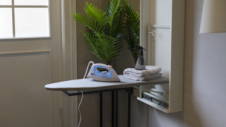 Built-in ironing board unit with iron and spray bottle