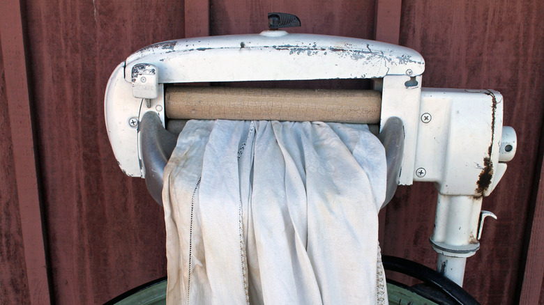 Vintage wringer washer with white linen cloth in rollers