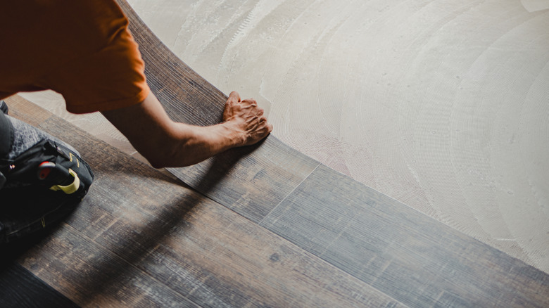 Person installing vinyl planks on floor