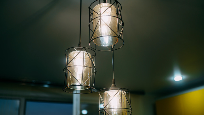 Dim metal pendant lights hanging from a ceiling