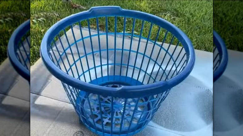 Blue plastic laundry basket sitting outside
