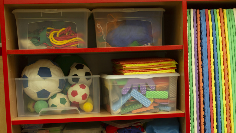 Toys stored in plastic bins on a shelf