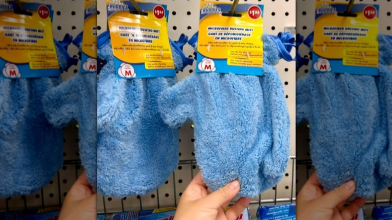 Hand grabbing scrub mitts on store display wall