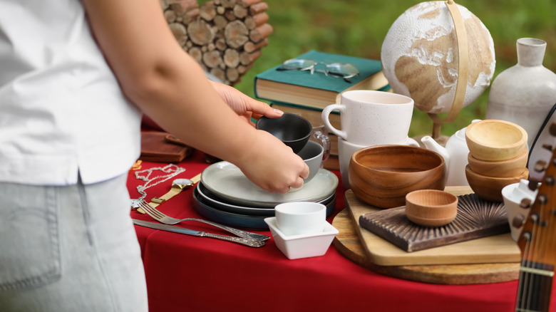 Woman holding bowls at a garage sale