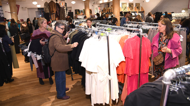 Shoppers in a thrift store looking at garments