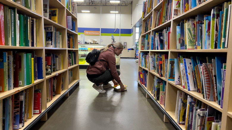Woman picking up fallen items at Goodwill