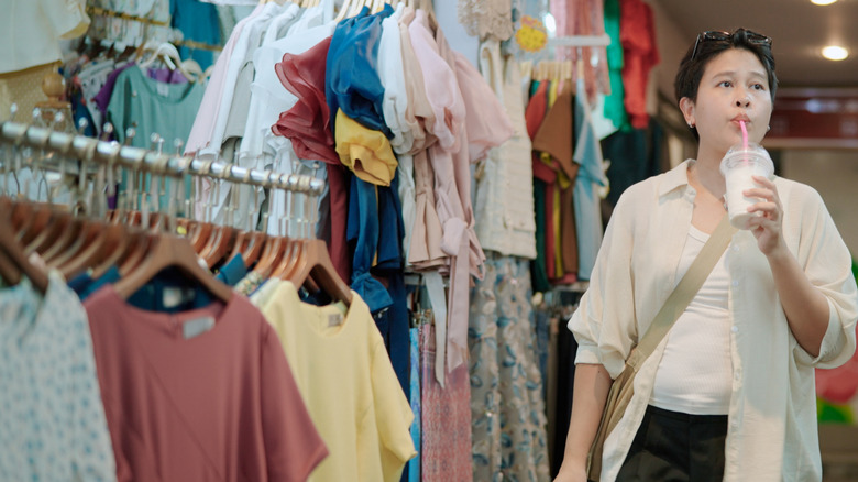 Woman drinking a beverage while shopping
