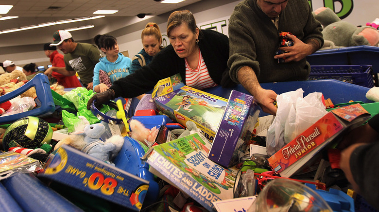 People diving in a large bin holding toys and games