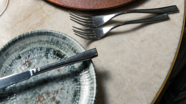 Copper charger plate with white napkin in copper napkin ring on a fall table