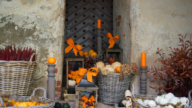 Assorted wicker and woven baskets filled with pumpkins, branches and gourds