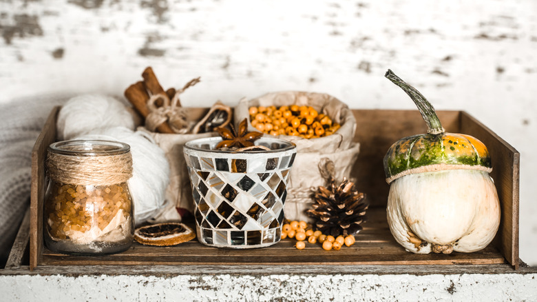 Cinnamon, pine cones and other spices and food items in ceramic and glass jars on display in a wooden crate