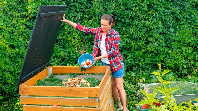 Woman throwing scraps into compost