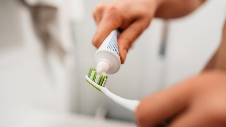Person squeezing toothpaste out of tube