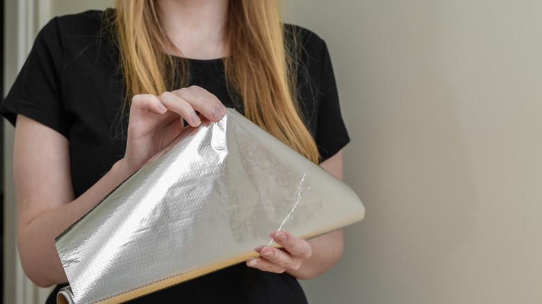 Woman holding roll of aluminum foil