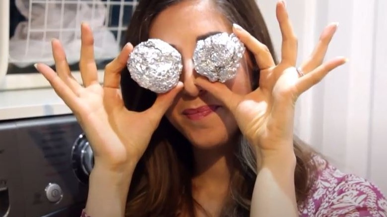 Woman with two aluminum foil balls in laundry room