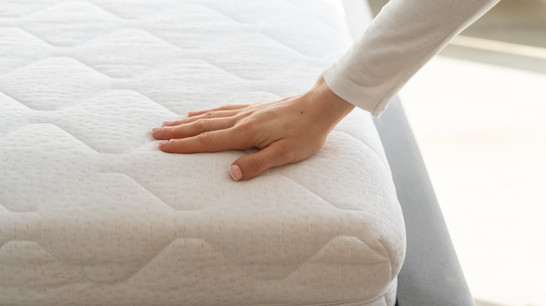 Woman feeling a white mattress