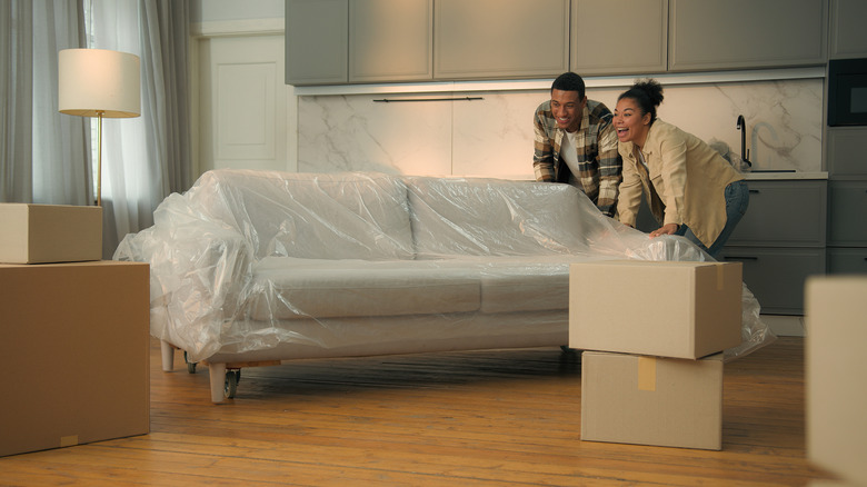 Couple moving couch into new home