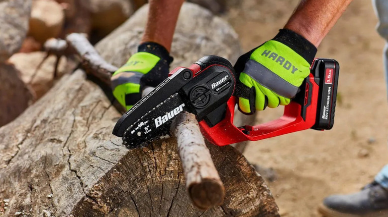 A worker wearing gloves sawing good with the BAUER saw.