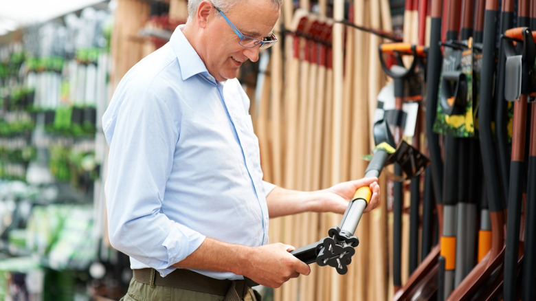 A man shopping for gardening tools at a store