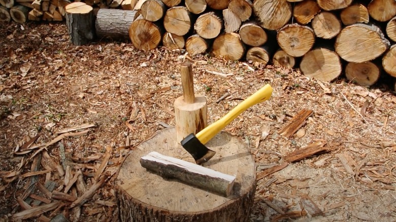 The yellow fiberglass mini axe from Harbor Freight on a log.
