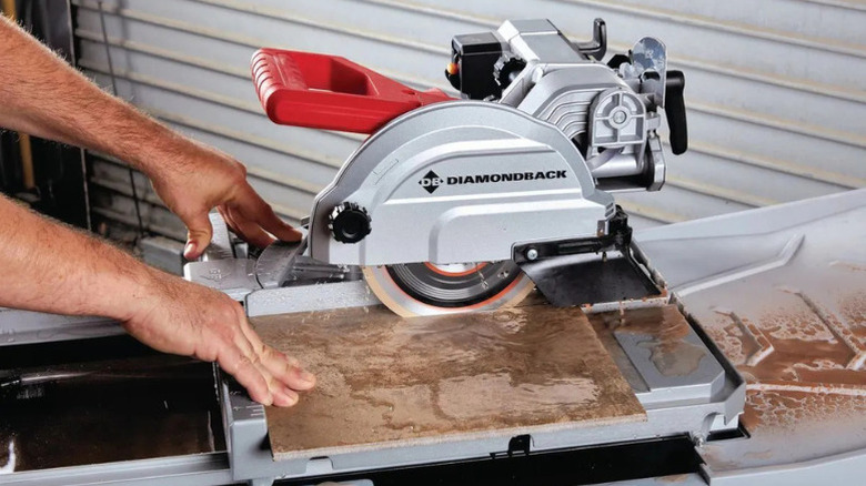 A person using Diamondback's 10-Amp, 7 in. Wet Tile Saw