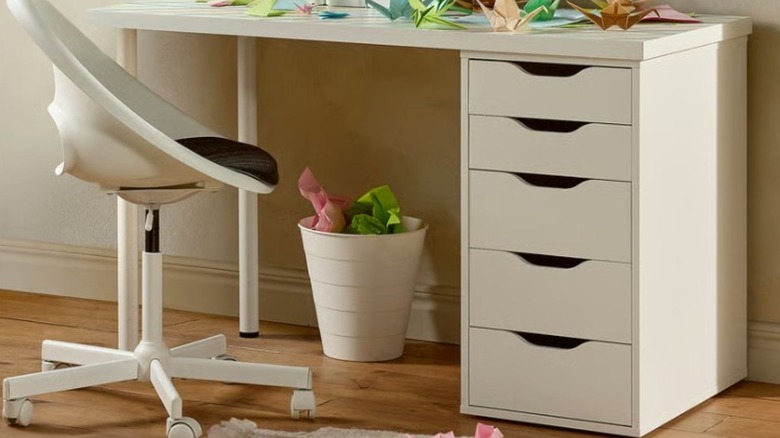Desk storage shelves with a trash can and chair