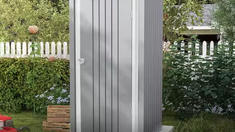 The tall Patiowell compact storage shed in a fenced in backyard.