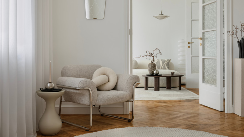white boucle chair and side table in corner of room