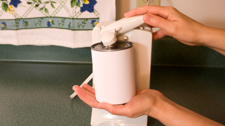 Person using electric can opener